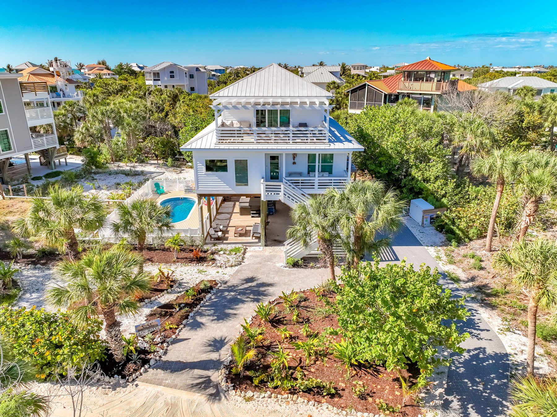 Coconut Cottage from above — white stilt home with private heated pool